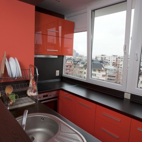 Ekli balkonda kırmızı ve siyah mutfak